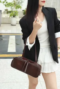 Dark brown genuine leather shoulder bag, minimalist bowling bag style, daily fashion detail.