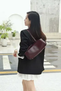 Details of the minimalist vegetable tanned leather bowling shoulder bag worn by model.