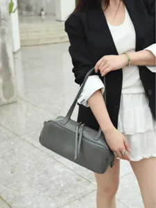 Minimalist vegetable-tanned cowhide bowling bag, stylish grey Boston handbag for women.