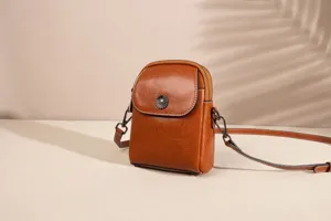Close-up detail view showing the elegant brown leather vertical crossbody cell phone bag.