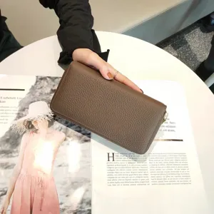 Detailed view of brown genuine leather long zipper wallet with classic texture and multiple slots.