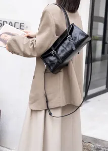 Borsa a tracolla nera da donna in pelle stropicciata con doppie fibbie in stile retrò.