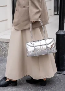 Dettaglio borsa a spalla argento effetto craquelé, stile vintage con cinturini sottili.