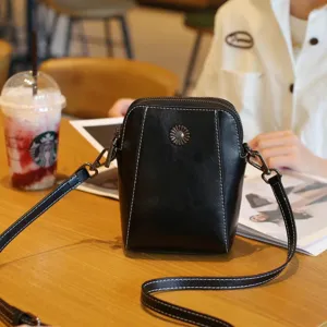 Vue détaillée du sac bandoulière pour téléphone en cuir ciré femme avec coutures contrastées.