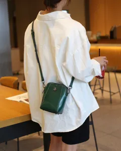 Sac bandoulière téléphone en cuir vert foncé vue détaillée, compact et élégant au quotidien.