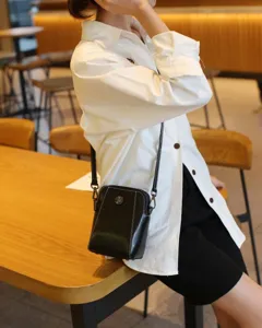 Sac bandoulière en cuir noir, petit sac pour téléphone avec détail en métal pour un usage quotidien.