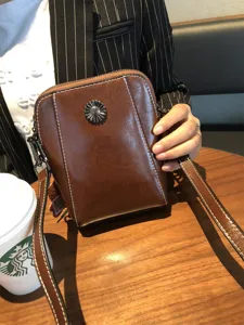 Vintage oil-wax split leather cross-body phone bag with metal flower snap and long strap.