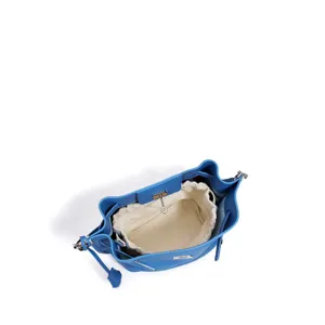 Detailed view of blue leather bucket bag interior featuring a secure drawstring pouch and lock.