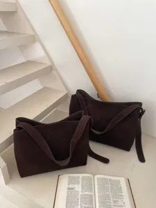 Detailed shot of dark brown suede shoulder tote bag, daily commuter style and texture.