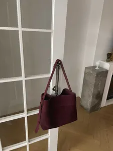 Detailed view of a stylish burgundy suede tote bag, large capacity, perfect for daily commute.