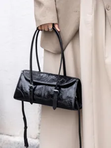 Borsa a spalla nera da donna in pelle craquelé con doppia tracolla e fibbie metalliche.