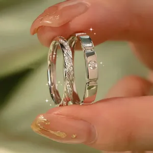 Close-up of elegant silver couple rings with sparkling diamonds, detailed design.