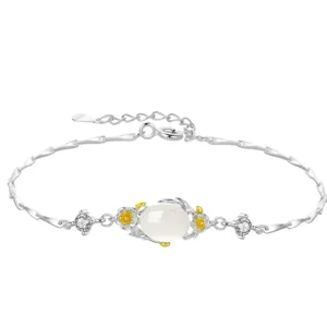 Close-up of Chinese style silver flower bracelet with white center bead and sparkling stones.