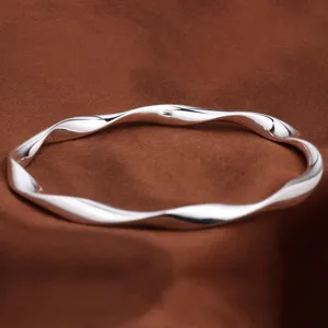 Bracelet jonc torsadé argenté Mobius, élégant design métallique massif fermé pour femmes.