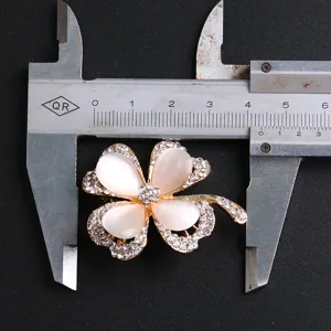 Four-leaf clover cat's-eye brooch with crystal pavé shown with measurement caliper