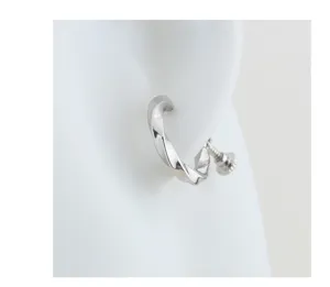 Vista detallada del pendiente de presión Mobius plateado para hombre estilo minimal.
