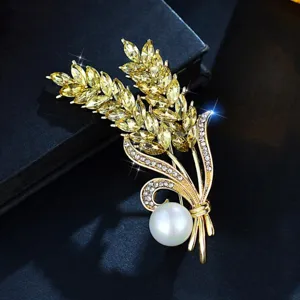 Elegant gold wheat ear brooch featuring yellow crystals, sparkling rhinestones and a white pearl.