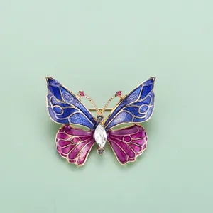 Vue détaillée d'une superbe broche papillon en émail bleu et violet avec des strass brillants.