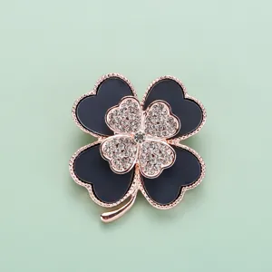 Gros plan détaillé de l'élégante broche trèfle à quatre feuilles ornée de strass brillants.