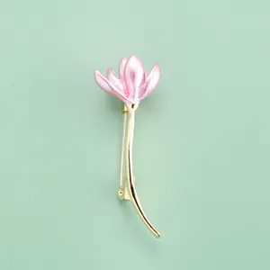 Vue detaillee d'une charmante broche fleur de tulipe rose avec tige doree, accessoire elegant.