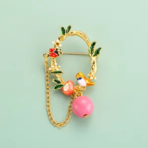 Détail de broche oiseau et branche émaillé exquis, accessoire de bijou de mode en or élégant.