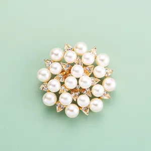 Détail de broche fleur perles et strass, accessoire élégant ton or pour vêtement.