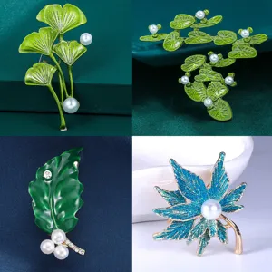Dettaglio spilla pianta con design in smalto foglia di ginkgo loto e acero con perle.