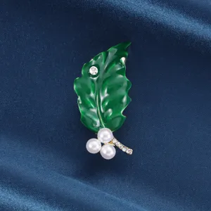Squisita spilla a foglia verde con smalto lucido, perle e strass per elegante decorazione.