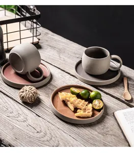Detalle de taza y platillo de café de cerámica retro japonesa, diseño bicolor minimalista.