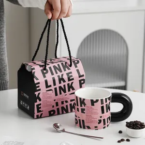 Taza de café de cerámica creativa con caja de regalo y asa negra, ideal para uso diario en la oficina.
