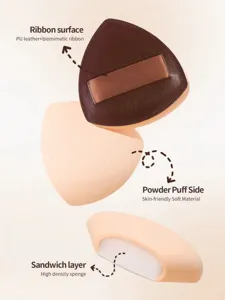 Triangle makeup puff detail view showing leather ribbon surface and soft sponge layer.