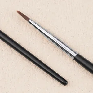 Primer plano detallado de pincel de maquillaje de ojos fino con cerdas marrones y férula.
