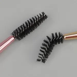Double ended eyebrow eyelash brush detail, professional makeup tool with black bristles.