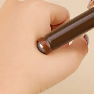 Detalle en primer plano de la bola de masaje de metal portatil en la piel con mango marron.