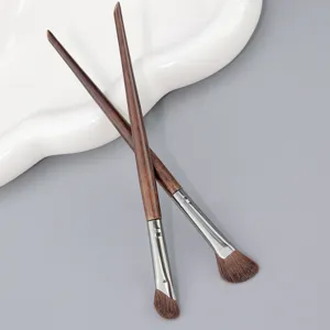 Gros plan détaillé de pinceaux de maquillage en bois biseautés à poils doux pour un contouring précis.