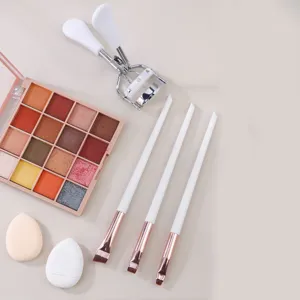 Makeup brush set with eyeshadow palette, eyelash curler, and beauty blender sponges for daily use.