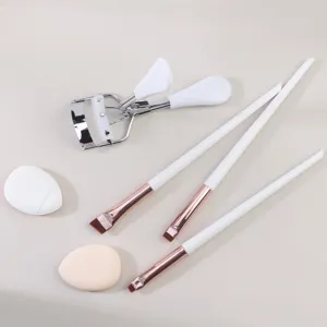 Detailed view of white makeup brush, comb eyelash curler and soft beauty sponge set tool.