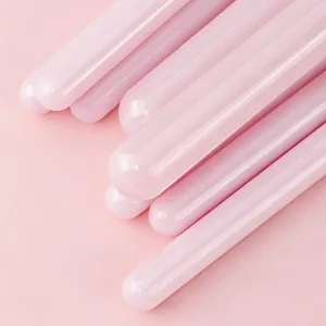 Dettaglio manico pennello trucco rosa, design cilindrico liscio, estetica elegante.