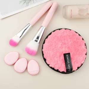 Vista dettagliata del set di pennelli da trucco rosa e soffici puff per la polvere.