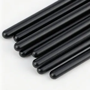 Close-up detail shot of professional makeup brush handles, sleek black matte finish design.