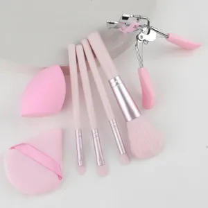 Detailed view of pink makeup brush set, sponge and eyelash curler for daily beauty