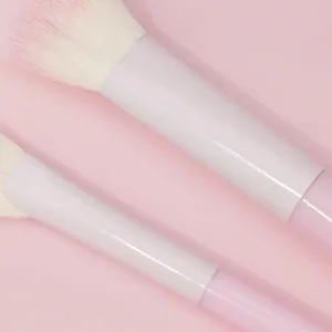 Primo piano dettagliato dei pennelli da trucco rosa morbidi con manico sfumato per applicazione.