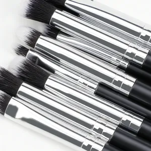 Close-up detail of professional eye makeup brush set featuring soft bristles and silver tubes.