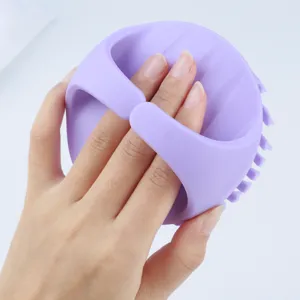 Close-up detail of the ergonomic purple silicone scalp massager brush with handle grip.