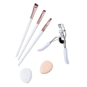 Set of 3 angled eyeliner makeup brushes, eyelash curler, and soft puffs for precise cosmetic application.