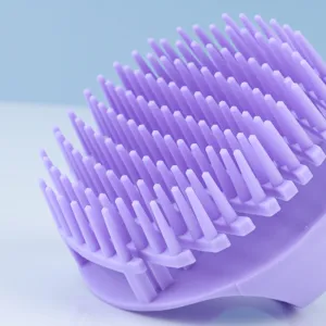 Close-up of purple silicone scalp massager brush with soft flexible bristles for daily bath.