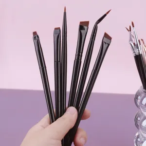 Detail shot of professional black makeup brush set, including eyeliner and angled eyebrow brushes.
