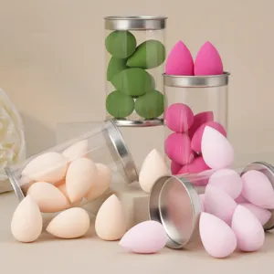 Set of mini makeup sponge blending puffs in transparent PVC round containers for flawless application.