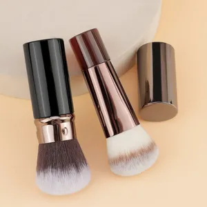 Detail view of portable retractable makeup brushes with metal covers and soft bristles.