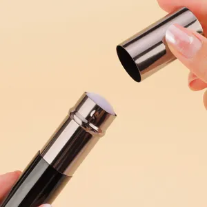 Closeup of portable retractable makeup brush with metal case and soft bristles for travel.